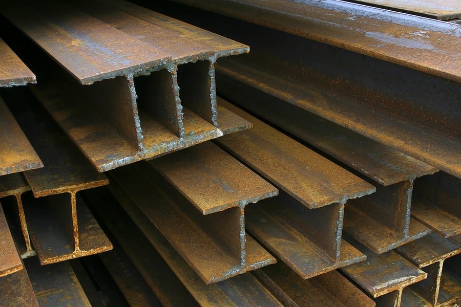Close-up of rusty steel beams stacked at a construction site