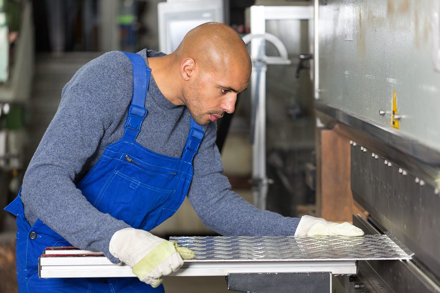 worker cambering a sheet of steel